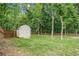 Large, grassy backyard with a storage shed and a wooden privacy fence at 61 Harmony Woods Ln, Dallas, GA 30157