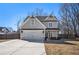 Two-story house with gray siding, a large driveway, and a fenced backyard at 61 Harmony Woods Ln, Dallas, GA 30157