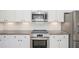 Modern kitchen features stainless steel appliances, granite counters, and white subway tile backsplash at 61 Harmony Woods Ln, Dallas, GA 30157