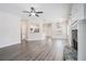 Open-concept living room with wood-look floors, a stone fireplace, and a view of the kitchen at 61 Harmony Woods Ln, Dallas, GA 30157