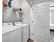 Laundry room features white washer and dryer, wire shelving, and a view to the bedroom at 401 16Th Nw St # 1376, Atlanta, GA 30363