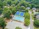 Aerial shot of the community pool and tennis courts with nearby parking lot nestled among mature trees at 4478 Outpost Ct, Roswell, GA 30075