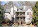 A serene view of the home's rear exterior, showcasing a multi-level deck with a seating area and a beautifully landscaped yard at 4478 Outpost Ct, Roswell, GA 30075