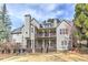 Two-story home showcasing a large backyard and a large deck with covered porch above at 4478 Outpost Ct, Roswell, GA 30075
