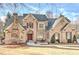 Stunning brick home with a stone chimney, manicured lawn, and a charming outdoor seating area at 4478 Outpost Ct, Roswell, GA 30075
