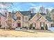 Beautiful two-story brick home with a well-maintained lawn, stone chimney, and lovely curb appeal at 4478 Outpost Ct, Roswell, GA 30075