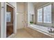 Bright bathroom with a soaking tub, walk-in shower, tile floors and built-in shelving at 305 Glengarry Chase, Covington, GA 30014