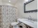 Charming bathroom with a marble countertop, a unique mirror, and a floral shower curtain at 305 Glengarry Chase, Covington, GA 30014