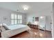 Bright bedroom showcasing hardwood floors, shuttered windows, a full-length mirror, and ample natural light at 305 Glengarry Chase, Covington, GA 30014