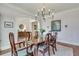 Dining room featuring a wooden table set for six, with elegant decor and hardwood flooring at 305 Glengarry Chase, Covington, GA 30014