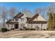 Charming gray brick two-story home with lush front lawn, mature trees, and elegant architectural details at 305 Glengarry Chase, Covington, GA 30014