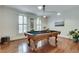 Bright game room featuring a classic pool table, hardwood floors, and plantation shutters at 305 Glengarry Chase, Covington, GA 30014