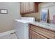 Well-organized laundry room with modern washer and dryer, granite countertop, and ample storage space at 305 Glengarry Chase, Covington, GA 30014