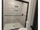 Contemporary bathroom with a stylish shower, featuring black hardware, gray tile, and a convenient built-in niche at 8970 Callaway Dr, Winston, GA 30187