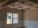 Elegant dining room showcases a coffered ceiling, wainscoting, and a large window overlooking the yard at 8970 Callaway Dr, Winston, GA 30187