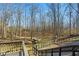 Beautiful backyard view with mature trees, a walking bridge, and a black ornamental fence at 201 Windflower Ct, Canton, GA 30115