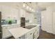 Bright kitchen featuring white cabinetry, a central island with cooktop, and a stylish backsplash at 201 Windflower Ct, Canton, GA 30115