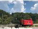 Historic Acworth caboose painted red is an eye-catching landmark, set against a backdrop of lush greenery and a bright sky at 4213 Legacy Ln # 32, Acworth, GA 30101