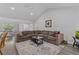 Spacious living room featuring a large sectional sofa, a coffee table, and hardwood floors at 3828 Briarstone Cv, Snellville, GA 30039