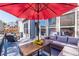 Relaxing back deck has patio set, red umbrella, and small table with flower arrangement at 115 Greenbrier Way, Canton, GA 30114