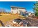 Expansive backyard includes a stone fire pit, wood fence, and a deck with outdoor furniture at 115 Greenbrier Way, Canton, GA 30114
