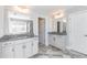 Dual vanity bathroom features marble countertops, white cabinets, framed mirrors, and chrome fixtures at 115 Greenbrier Way, Canton, GA 30114