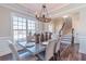 Bright dining room boasts a large window, decorative chandelier, and stairs to the second level at 115 Greenbrier Way, Canton, GA 30114