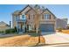 Charming two-story home featuring a stone facade, covered porch, and well-manicured lawn at 115 Greenbrier Way, Canton, GA 30114