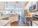 Gourmet kitchen featuring stainless steel appliances, granite countertops, and white cabinetry at 115 Greenbrier Way, Canton, GA 30114