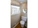 Simple toilet and window in a small bathroom at 1357 Ridgewood Dr, Lilburn, GA 30047