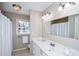 Clean bathroom with white vanity, shower, and updated light fixtures at 1357 Ridgewood Dr, Lilburn, GA 30047