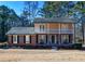 Charming two-story home with a brick facade, balcony, black shutters, and a well-manicured lawn at 1357 Ridgewood Dr, Lilburn, GA 30047