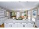 Open kitchen with granite island, white cabinets and hardwood floors at 1357 Ridgewood Dr, Lilburn, GA 30047