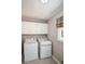 Laundry room with washer, dryer, and overhead cabinets at 1357 Ridgewood Dr, Lilburn, GA 30047