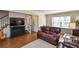Living room with hardwood floors, comfortable leather furniture, and a large TV at 1357 Ridgewood Dr, Lilburn, GA 30047