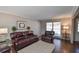 Spacious living room with hardwood floors, large windows, and comfortable leather furniture at 1357 Ridgewood Dr, Lilburn, GA 30047