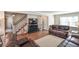 Bright living room featuring hardwood floors, a staircase, and a large TV at 1357 Ridgewood Dr, Lilburn, GA 30047
