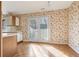 Cozy kitchen with floral wallpaper, wood parquet floors, white cabinets, and appliances at 1459 Hillpine Ne Ln, Atlanta, GA 30306