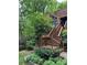 A beautiful entrance with wooden steps accented by flowering planters and verdant landscaping at 3457 Winter Wood Cv, Marietta, GA 30062