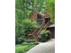 A beautiful entrance with wooden steps accented by flowering planters and verdant landscaping at 3457 Winter Wood Cv, Marietta, GA 30062