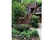 A beautiful entrance with wooden steps accented by flowering planters and verdant landscaping at 3457 Winter Wood Cv, Marietta, GA 30062