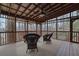Relaxing screened porch with seating, ceiling fan, and a picturesque view of the surrounding trees and nature at 3457 Winter Wood Cv, Marietta, GA 30062