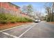 Exterior view with reserved parking spots by a brick apartment building with green shrubbery and a wooden fence at 424 Lindbergh Ne Dr # 111, Atlanta, GA 30305