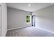 A well-lit bedroom with a plush carpet, window, and an interior door at 8971 Callaway Dr, Winston, GA 30187
