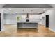 Open-concept kitchen with a large island, stainless appliances, hardwood flooring, and modern lighting at 8971 Callaway Dr, Winston, GA 30187