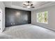 A spacious main bedroom featuring tray ceilings, a ceiling fan, and an accent wall at 8971 Callaway Dr, Winston, GA 30187
