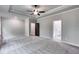 A spacious main bedroom with plush carpets, neutral walls, and tray ceilings with a ceiling fan at 8971 Callaway Dr, Winston, GA 30187