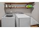 Laundry room with washer, dryer, and wooden shelves at 520 Andes Ln, Canton, GA 30114