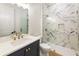 Bathroom boasts marble shower, navy vanity, and gold fixtures at 954 Carl Sanders Dr, Acworth, GA 30101
