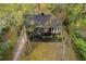 Aerial view of a cozy house with a well-manicured lawn and driveway nestled among lush trees at 2597 Elsinore St, East Point, GA 30344